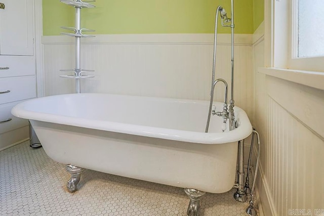 bathroom with a bath and tile patterned flooring