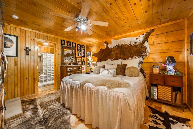 bedroom with wood ceiling, wood-type flooring, wooden walls, and ceiling fan