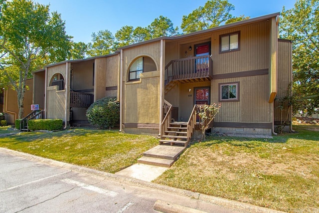 view of front of property with a balcony and a front lawn