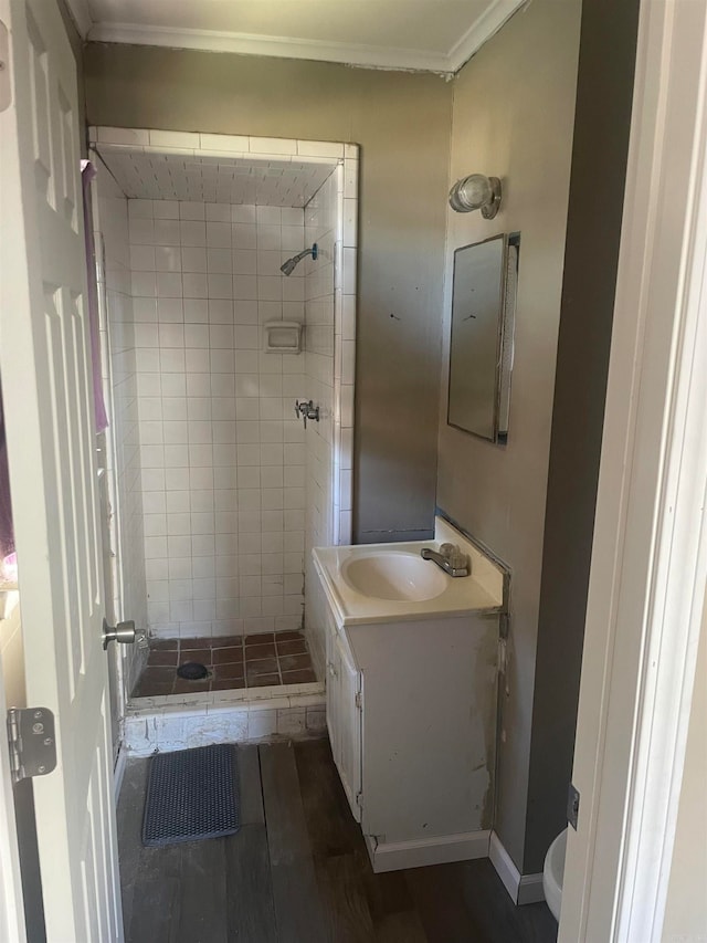 bathroom with vanity, hardwood / wood-style floors, a tile shower, and toilet