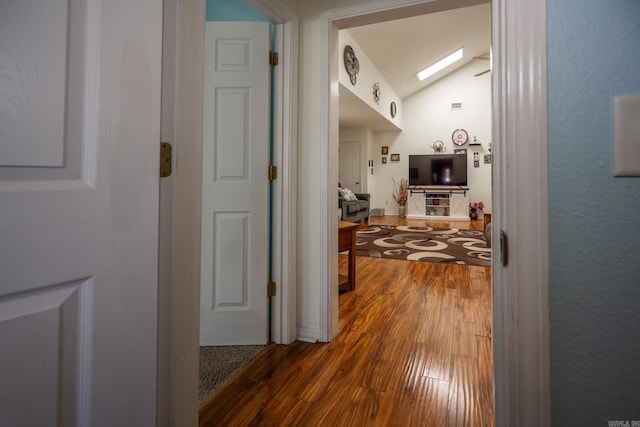 corridor featuring vaulted ceiling and dark hardwood / wood-style floors