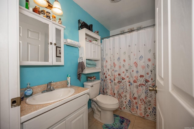 bathroom with vanity, toilet, tile patterned floors, and walk in shower