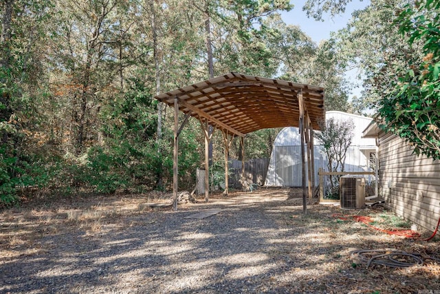 view of yard featuring a storage shed, central AC unit, and a carport