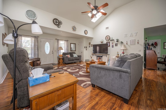 living room featuring dark wood-type flooring, ceiling fan, high vaulted ceiling, and a skylight