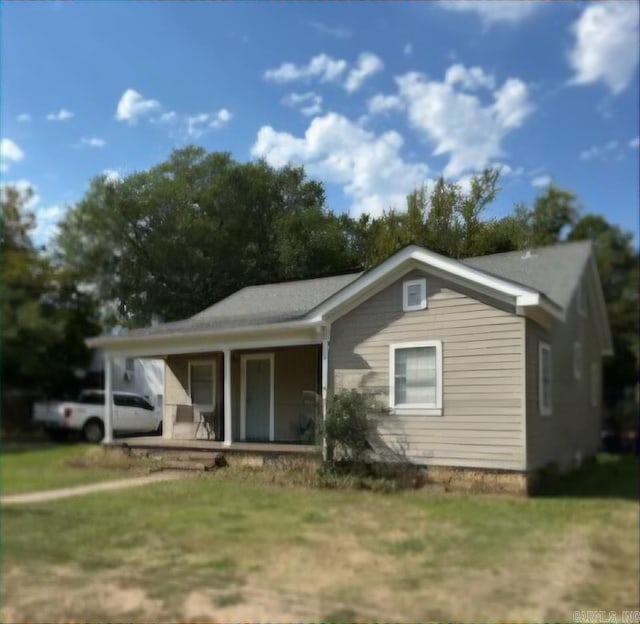 view of front of property featuring covered porch and a front yard