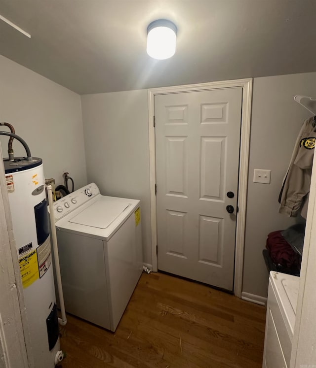 washroom with dark hardwood / wood-style flooring, washer / dryer, and electric water heater