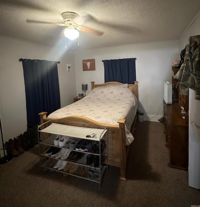 bedroom featuring dark carpet, a textured ceiling, and ceiling fan