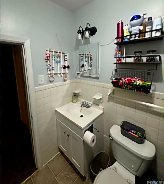 bathroom with tile patterned flooring, vanity, tile walls, and toilet