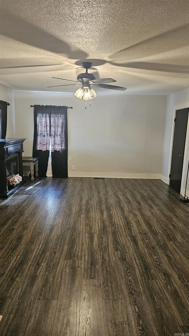 empty room featuring ceiling fan, dark hardwood / wood-style floors, and a textured ceiling