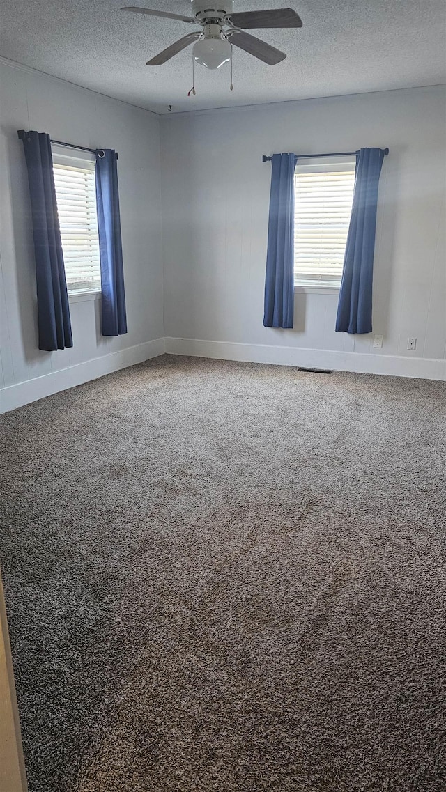 empty room with ceiling fan and a textured ceiling