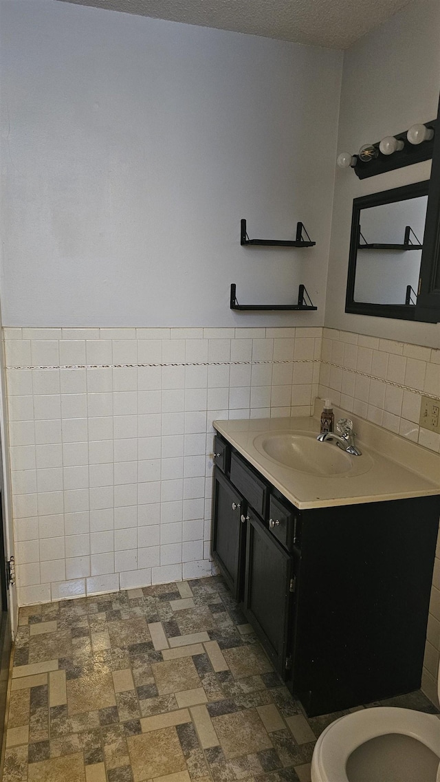 bathroom featuring vanity, tile walls, and a textured ceiling