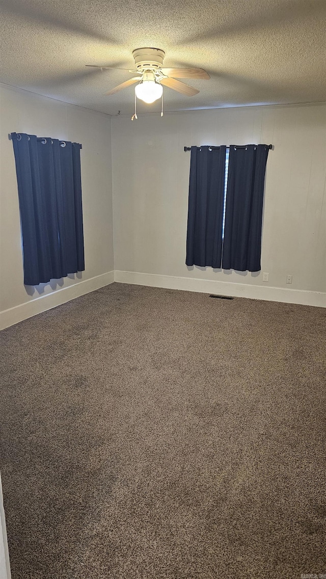 unfurnished room with ceiling fan and a textured ceiling