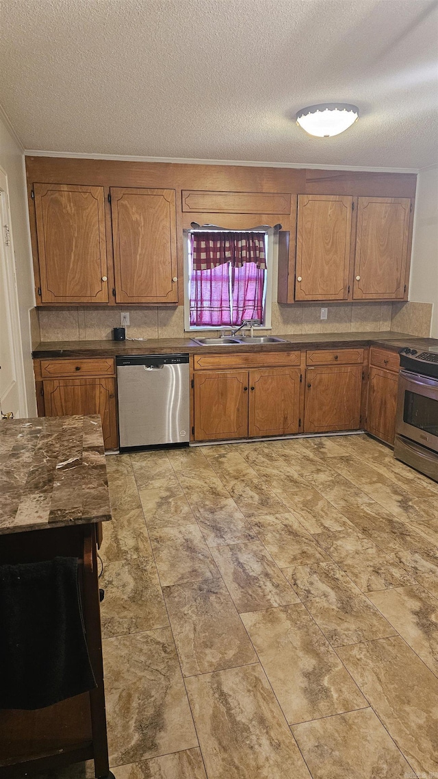 kitchen featuring tasteful backsplash, appliances with stainless steel finishes, sink, and a textured ceiling