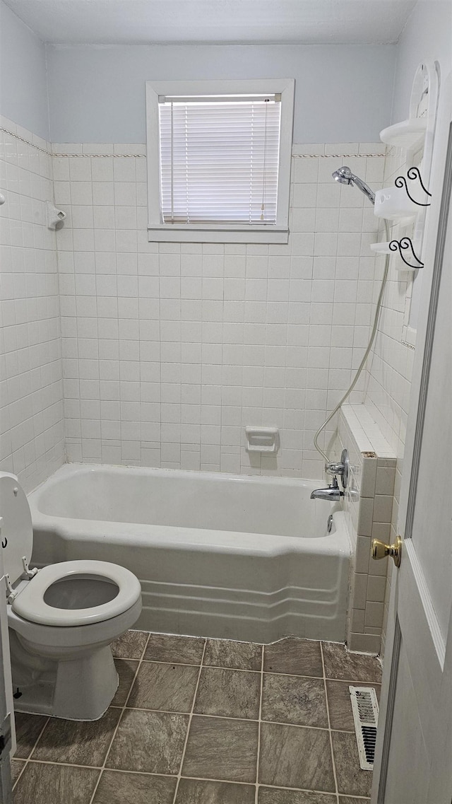 bathroom with tiled shower / bath and toilet