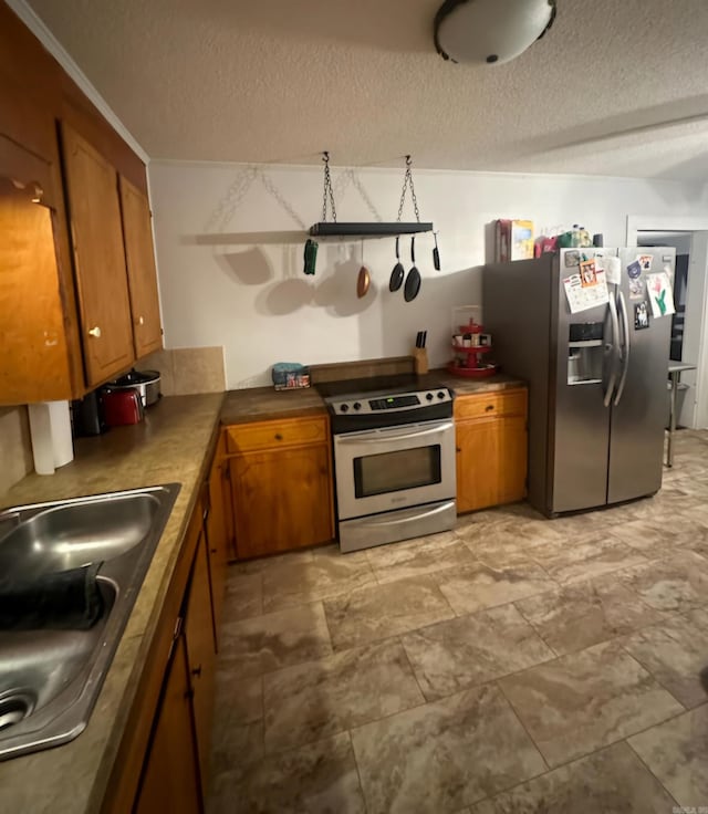 kitchen with stainless steel appliances, sink, and a textured ceiling