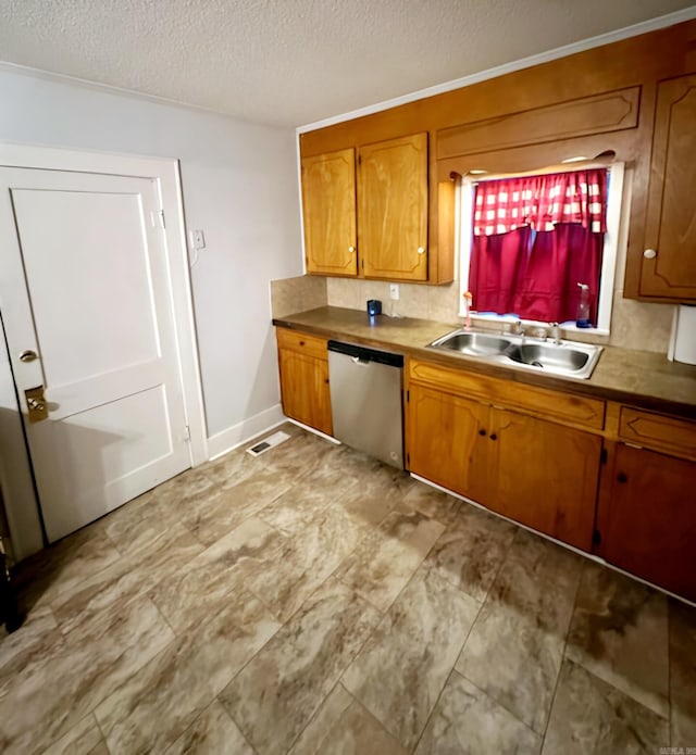 kitchen with stainless steel dishwasher, sink, a textured ceiling, and backsplash