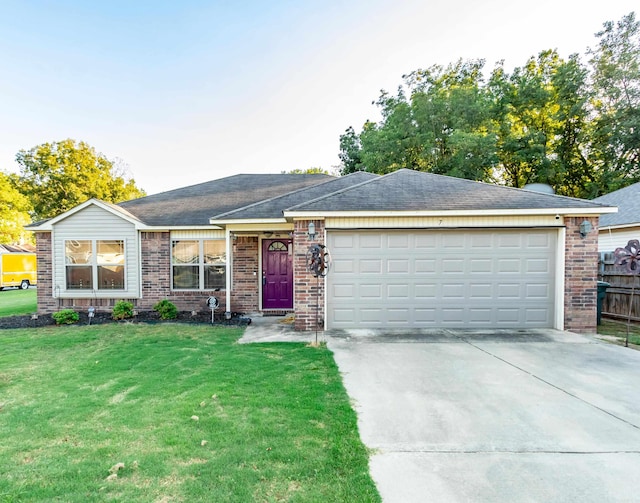 ranch-style house featuring a front yard and a garage