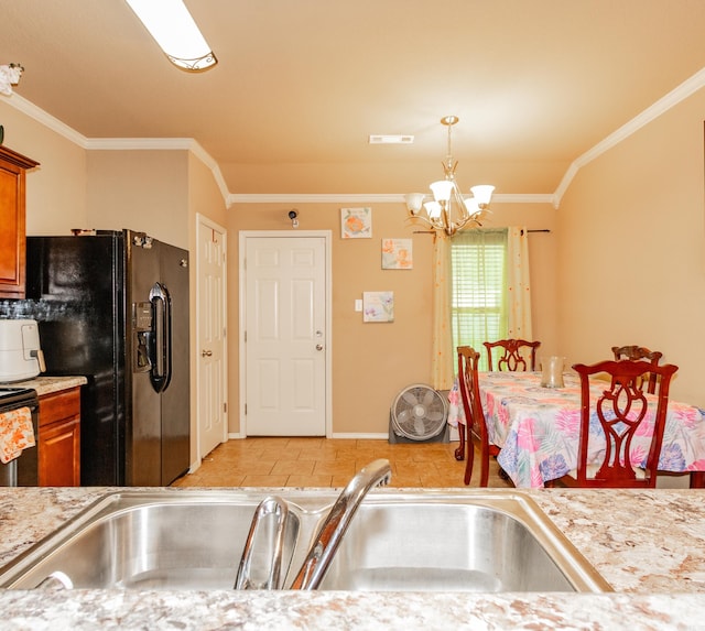 kitchen featuring crown molding, a chandelier, sink, and black fridge