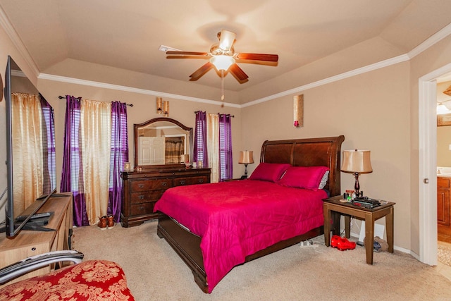 carpeted bedroom with crown molding, a tray ceiling, and ceiling fan