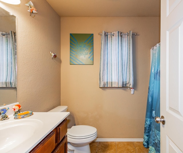 bathroom featuring vanity, toilet, and tile patterned flooring