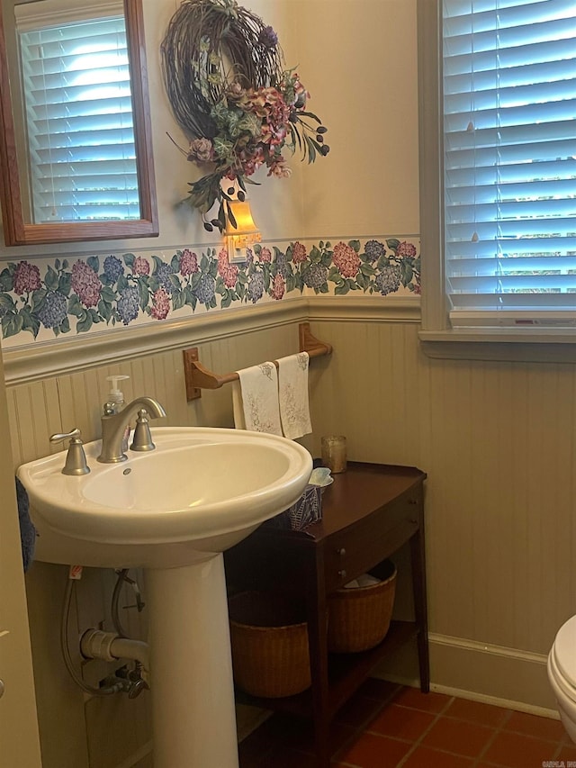 bathroom featuring tile patterned flooring, a healthy amount of sunlight, and toilet