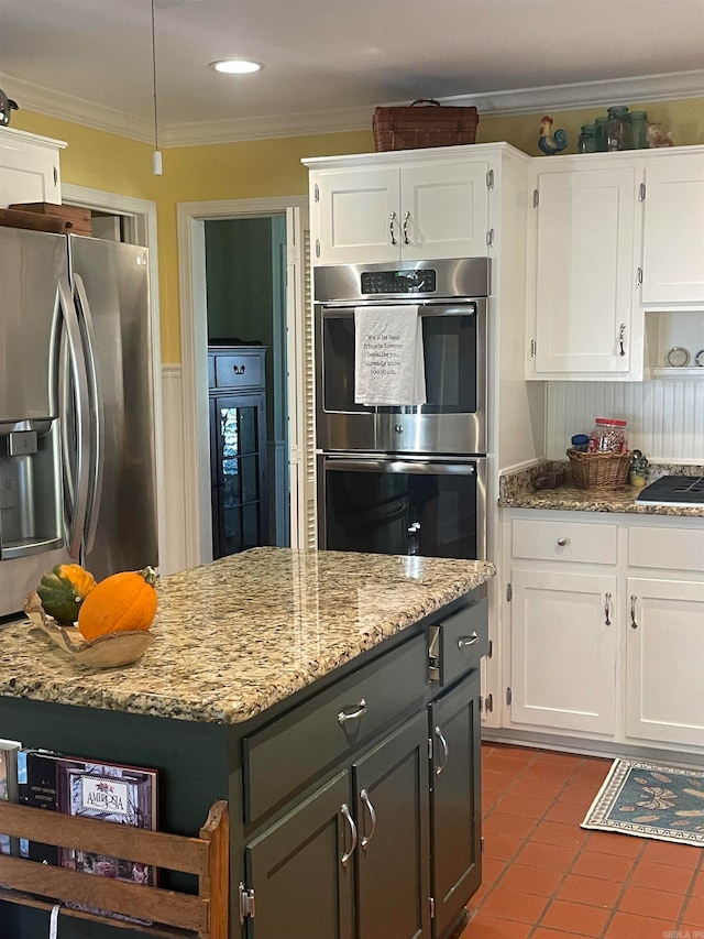 kitchen with white cabinets, appliances with stainless steel finishes, and crown molding