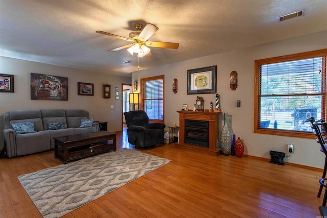 living room featuring hardwood / wood-style floors, a textured ceiling, and ceiling fan