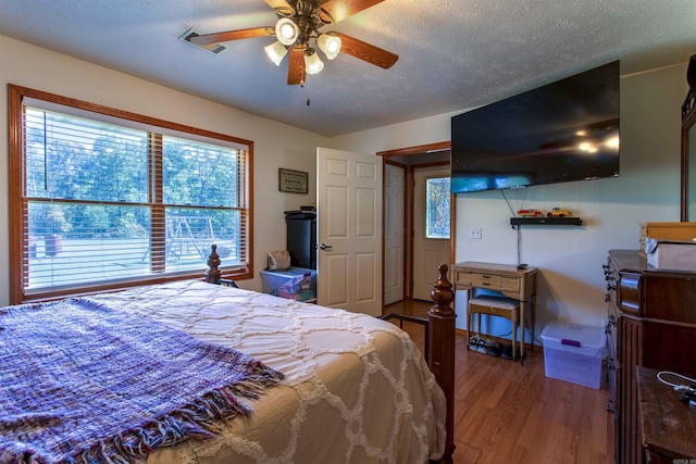 bedroom featuring hardwood / wood-style flooring, a textured ceiling, and ceiling fan