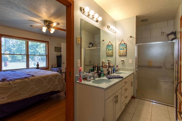 bathroom with a shower with door, a textured ceiling, tile patterned floors, and ceiling fan