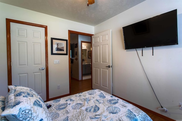 bedroom with wood-type flooring, a textured ceiling, and ceiling fan