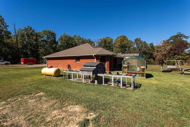 back of property with a yard and an outdoor structure