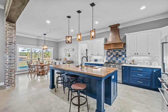 kitchen featuring high end range, white cabinetry, custom exhaust hood, blue cabinetry, and a center island with sink