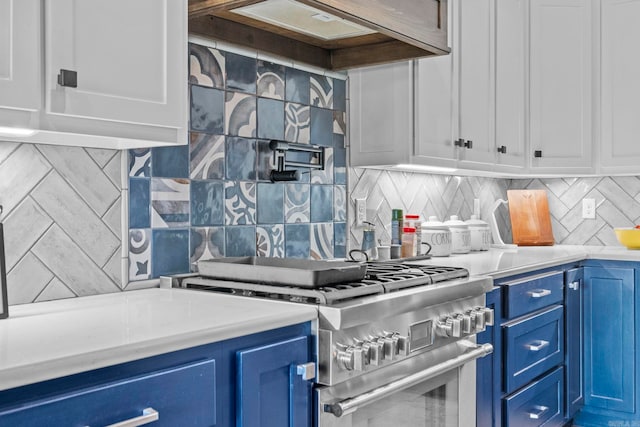 kitchen featuring premium range hood, tasteful backsplash, blue cabinets, and high end stove