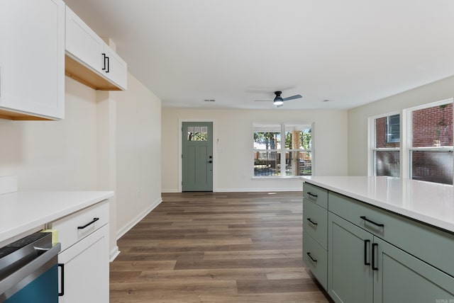 kitchen featuring white cabinetry, ceiling fan, stainless steel dishwasher, and dark hardwood / wood-style floors