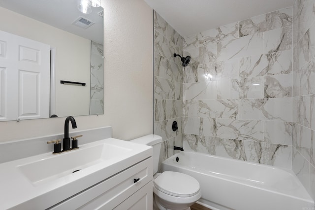 full bathroom featuring toilet, tiled shower / bath, and vanity