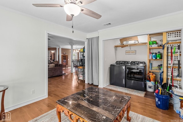 living room featuring wood-type flooring, washing machine and dryer, ornate columns, and ceiling fan