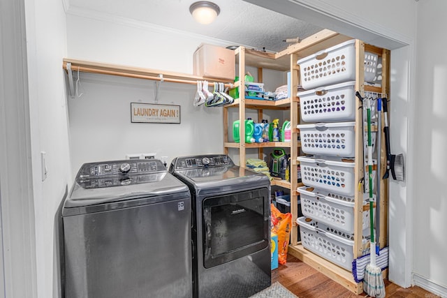 laundry area featuring independent washer and dryer, a textured ceiling, crown molding, and wood-type flooring