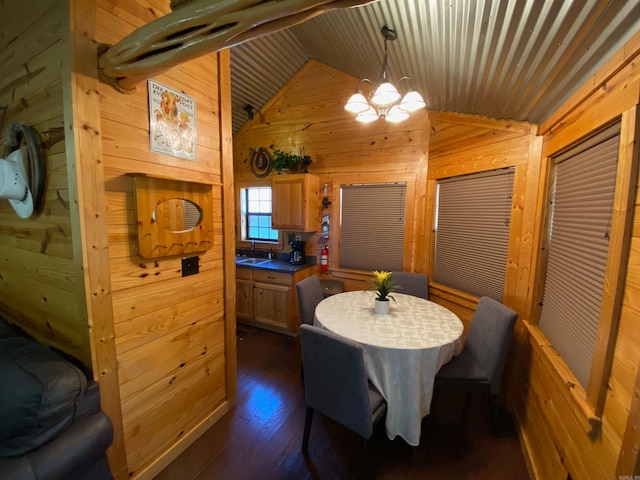 dining area featuring lofted ceiling, a notable chandelier, dark hardwood / wood-style floors, and wood walls