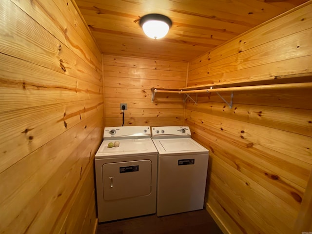 laundry room featuring wooden ceiling, separate washer and dryer, and wooden walls