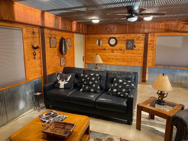 living room featuring wood walls and ceiling fan