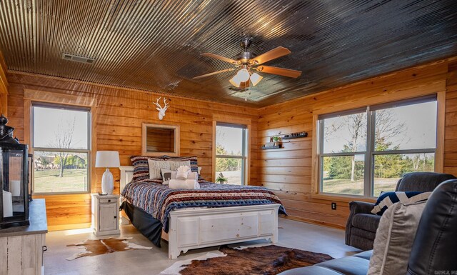 bedroom featuring ceiling fan and wooden walls