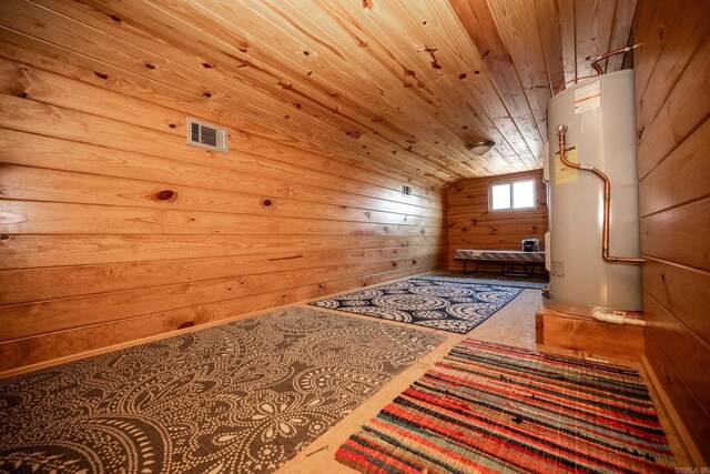 interior space with wood walls, water heater, vaulted ceiling, and wooden ceiling