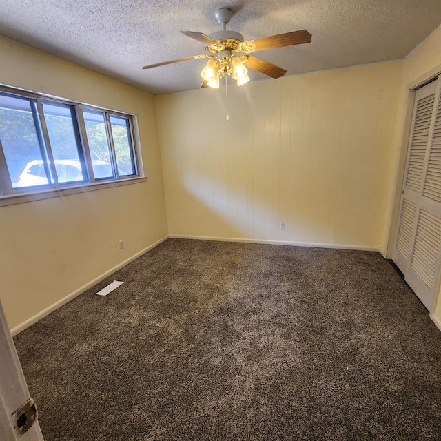 carpeted empty room featuring a textured ceiling and ceiling fan