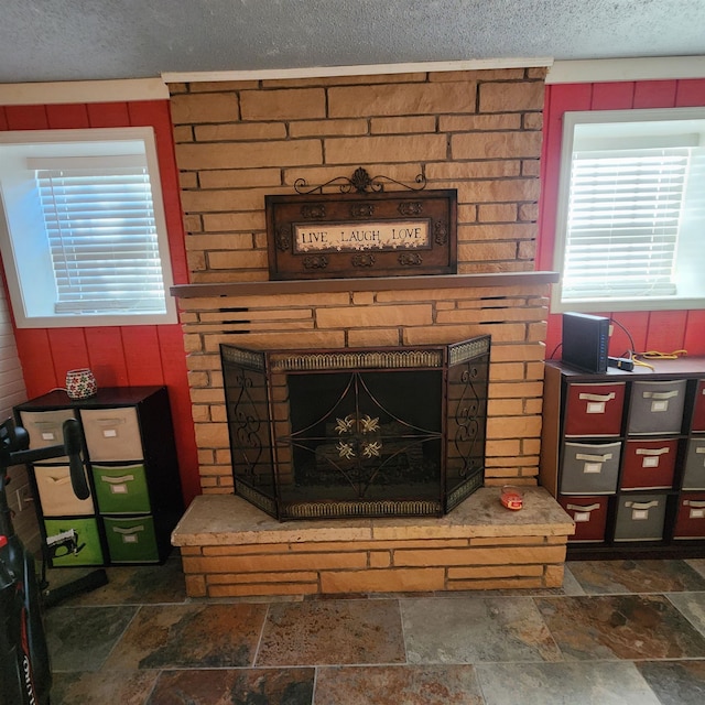 interior details featuring wood walls, a textured ceiling, and a brick fireplace