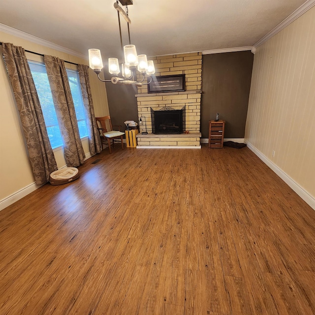 unfurnished living room featuring a stone fireplace, wood-type flooring, a chandelier, and crown molding