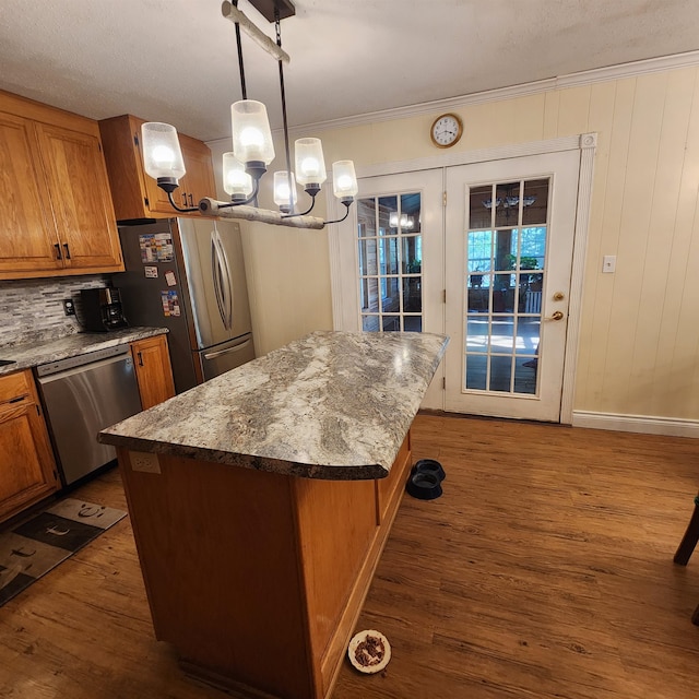 kitchen featuring tasteful backsplash, stainless steel appliances, a kitchen island, dark hardwood / wood-style floors, and hanging light fixtures