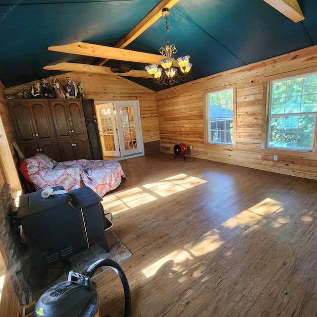 bedroom featuring wood walls, hardwood / wood-style flooring, vaulted ceiling with beams, and a notable chandelier