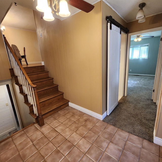 staircase with a chandelier, a barn door, crown molding, and carpet floors