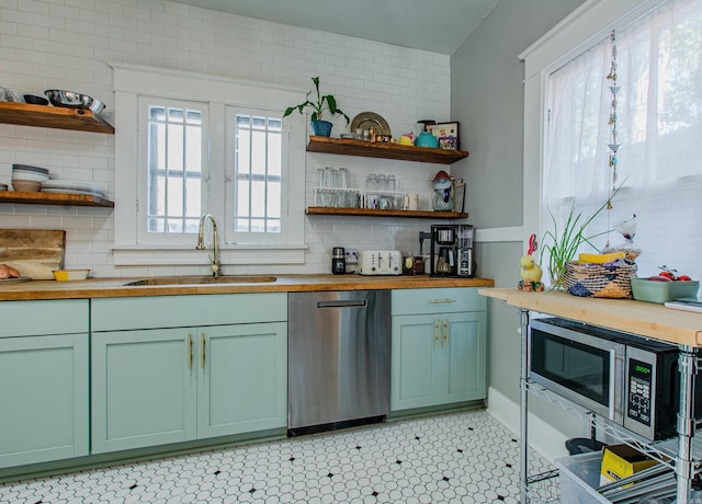 kitchen with butcher block countertops, a healthy amount of sunlight, appliances with stainless steel finishes, and sink