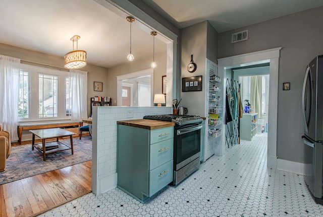 kitchen featuring hanging light fixtures, light hardwood / wood-style floors, wooden counters, stainless steel appliances, and green cabinetry